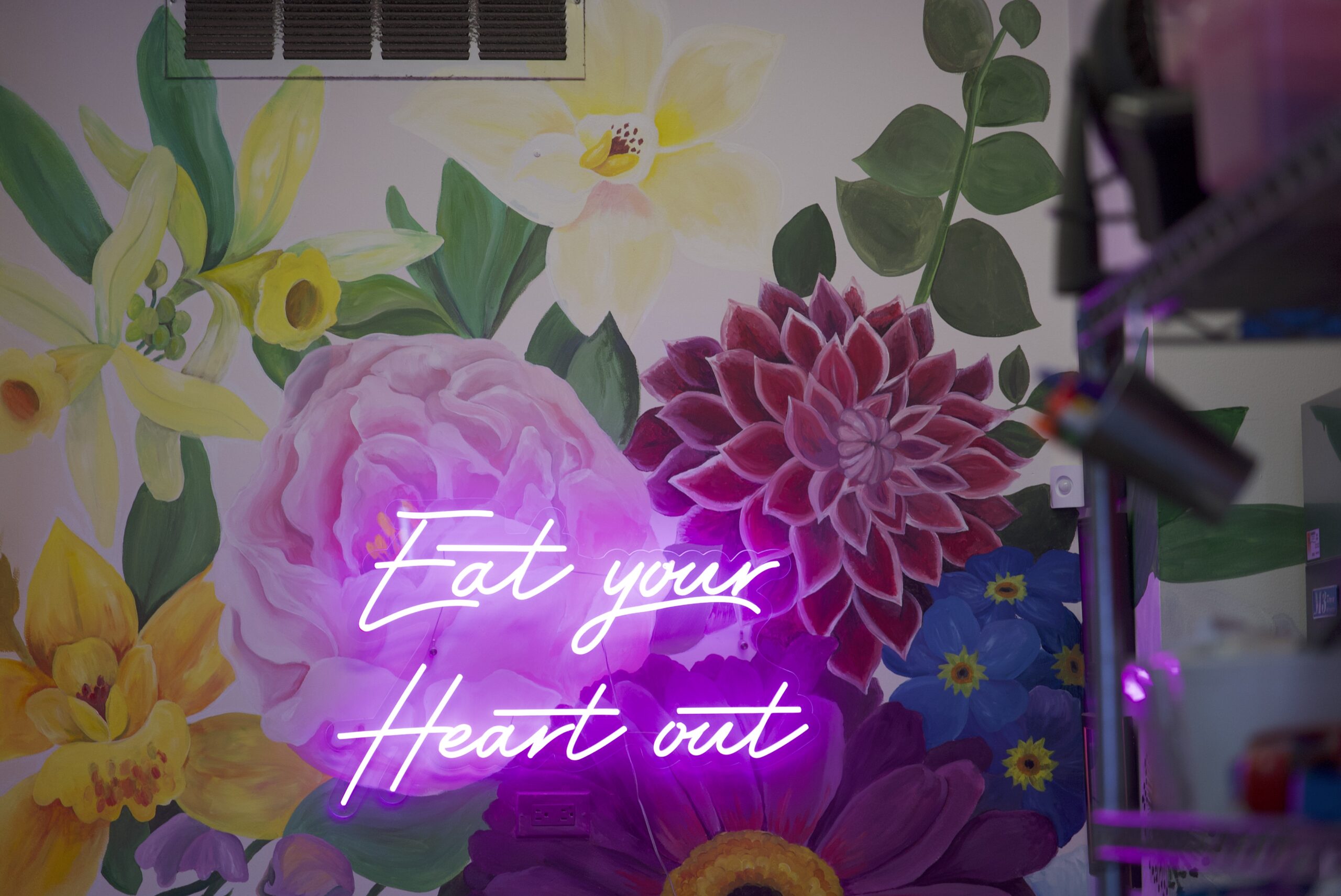 "Eat your Heart out" neon sign in store