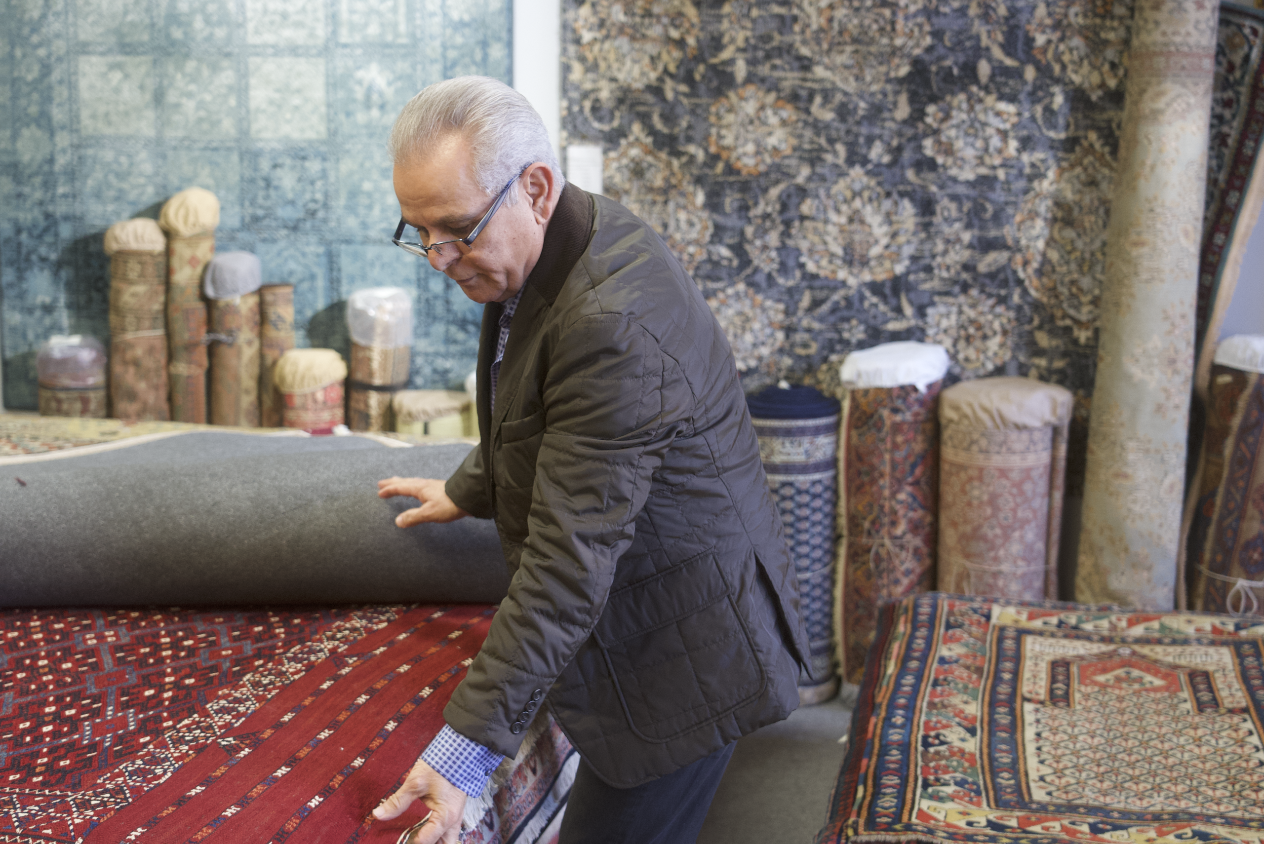 Owner examining rugs